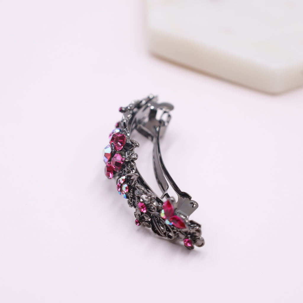 Side angle of the curved design pink fuchsia hair barrette with crystals