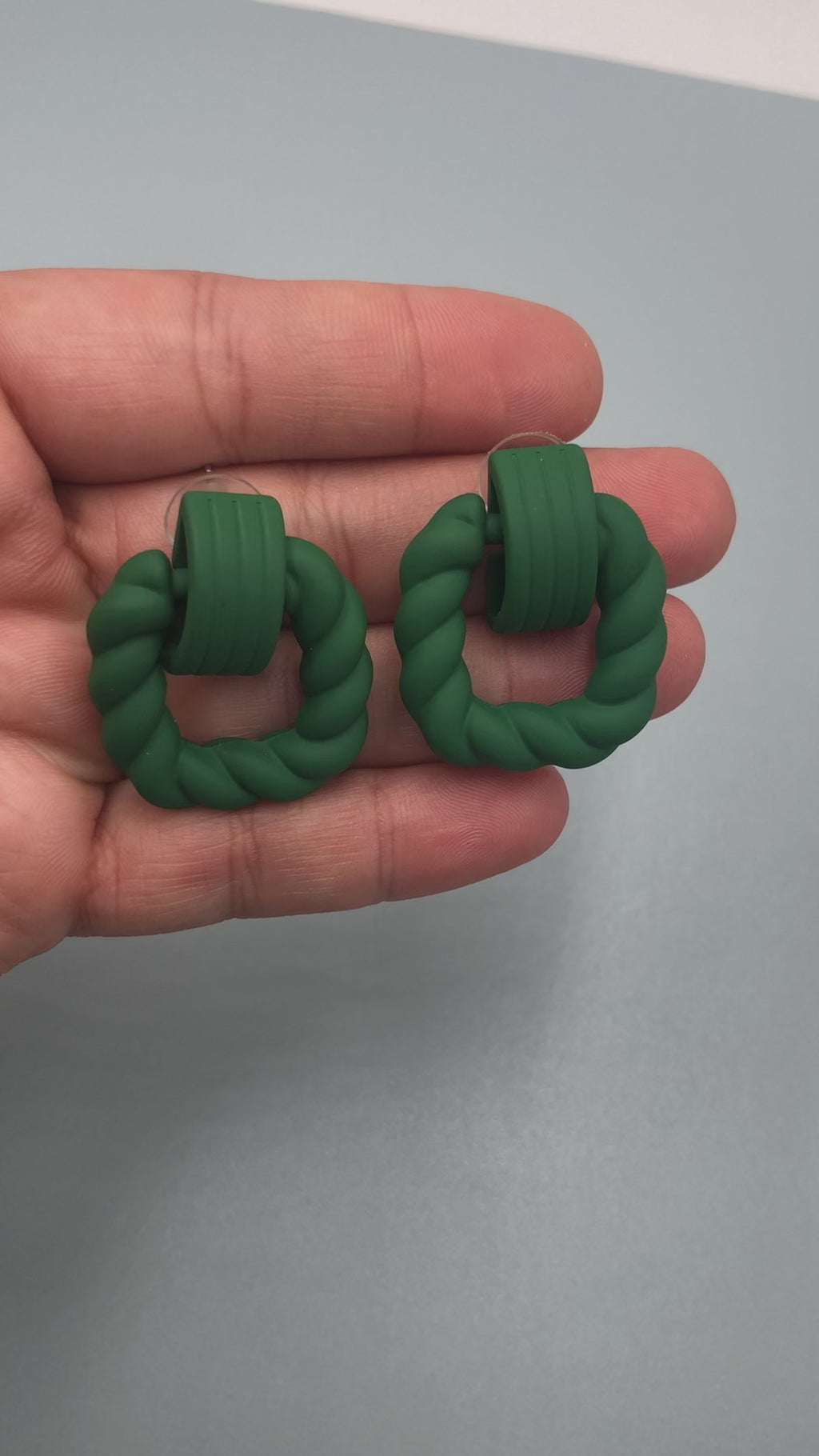 Women's drop earrings with a stunning dark green hue and twisted, modern design.
