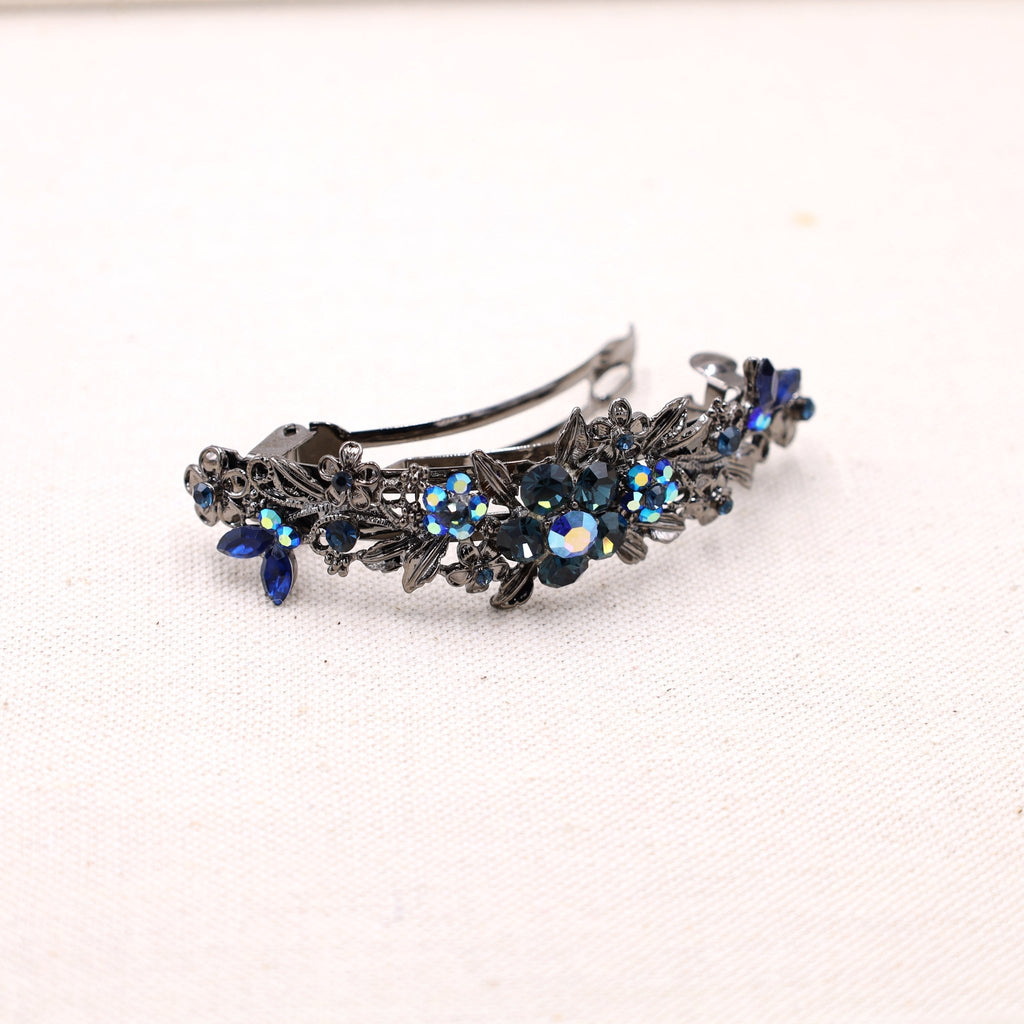 gray metal barrette with a delicate design of petals and flower in navy blue crystals