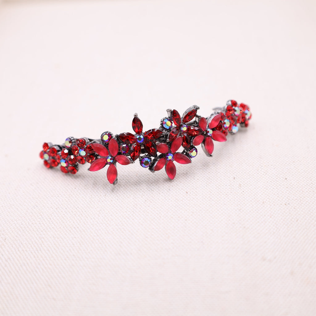 Red crystal hair barrette showcased on thick, flowing locks for a stunning look.