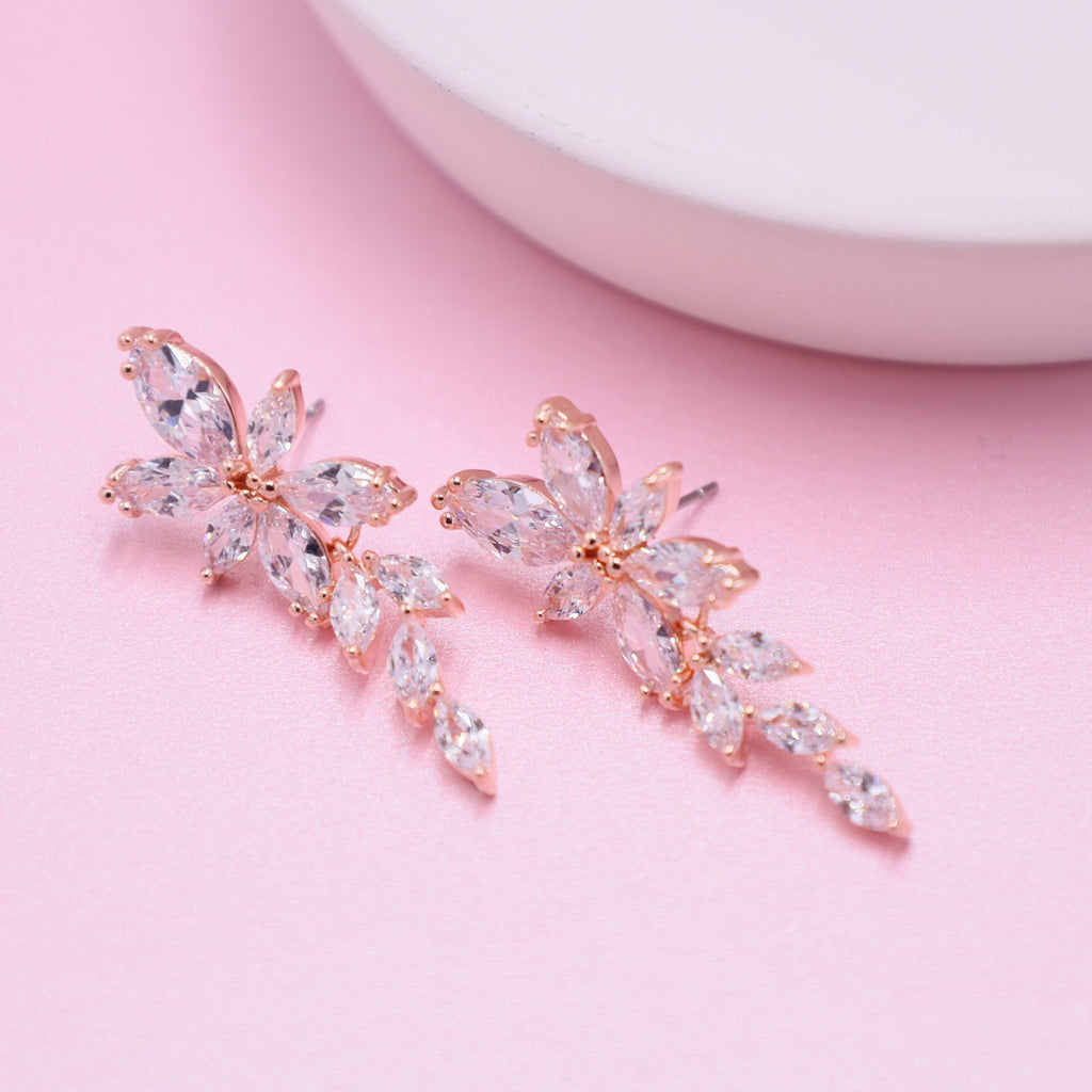 Captivating rose gold bridal earrings with shimmering clear crystals, ideal for enhancing wedding allure.