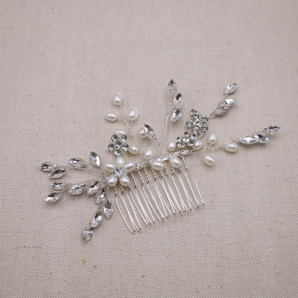 A simple and elegant bridal hair comb featuring delicate pearls and modern design.