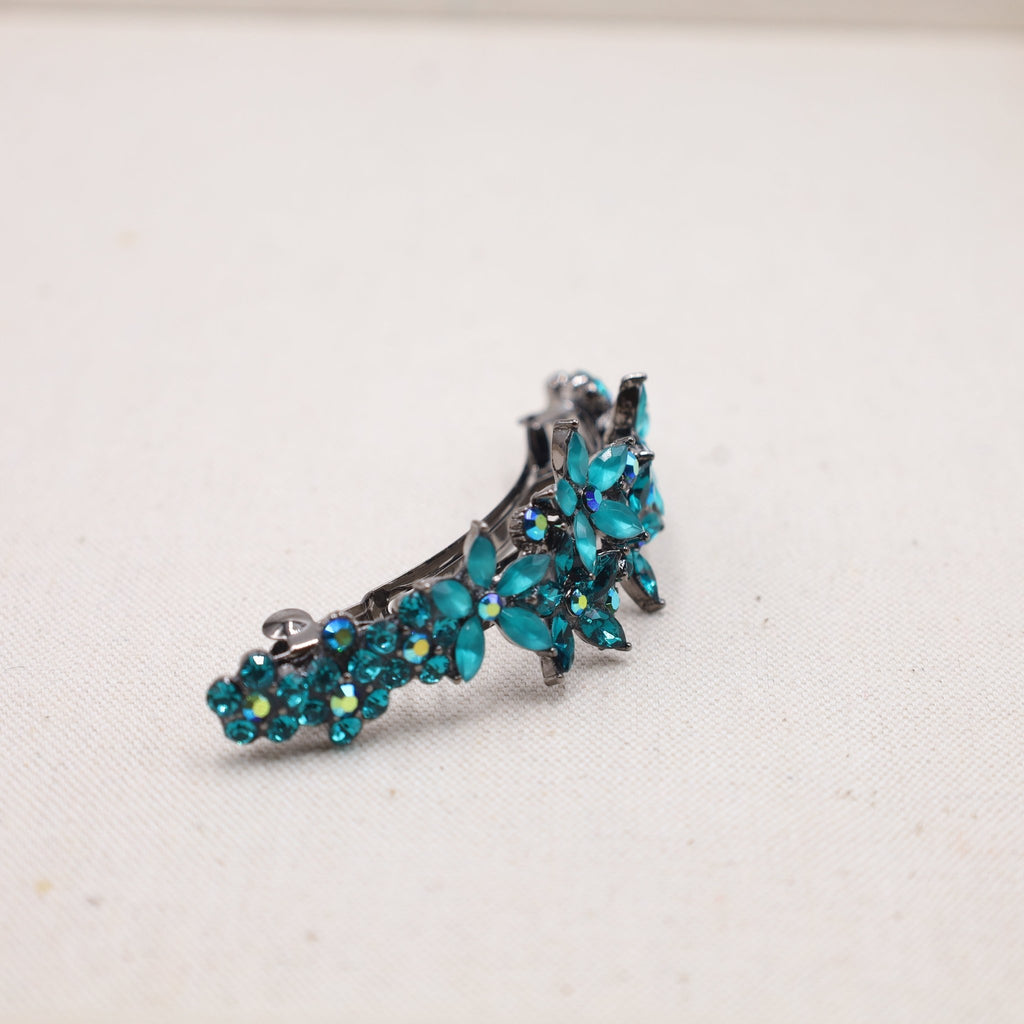A statement-making hair barrette in teal turquoise, crafted to hold and adorn thick, cascading locks.